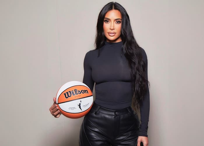 Kim Kardashian holds a WNBA basketball in a photo shoot.